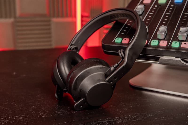 The AIAIAI DJ Headphones leaning against an audio mixing console .