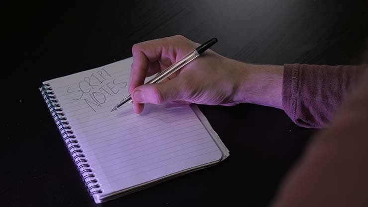 A person writing notes about their script