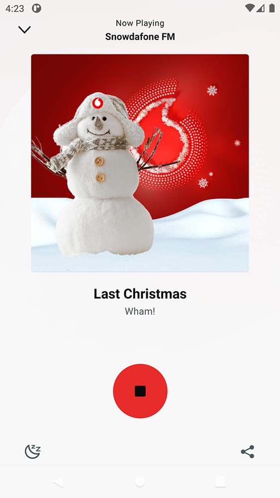 A screenshot from the SnowdaFone FM app, showing Last Christmas by Wham playing and a picture of a snowman against a red background with the red Vodafone symbol behind.