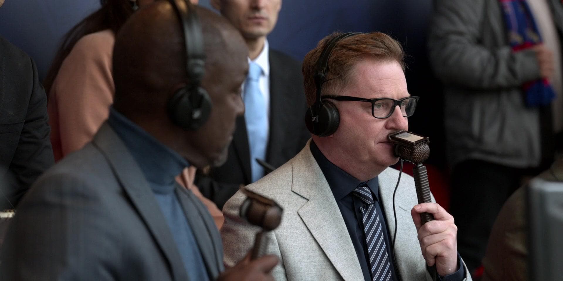 A still from the TV show, Ted Lasso, showing two commentators speak into Lip-Ribbon Mics.