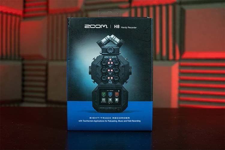 A Zoom H8 Box, upright on a table with a red background.