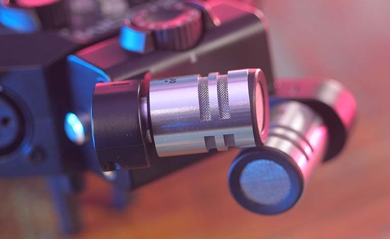 Close up of the silver, cylindrical Zoom XYH-6 Microphones attached to the Zoom H8 interface.